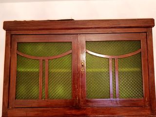 Alacena antigua de madera con puertas de cristal