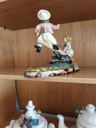 Figura antigua de niños en balancín