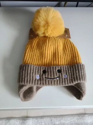 Berretto per bambini con pompon e paraorecchie