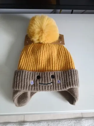 Berretto per bambini con pompon e paraorecchie