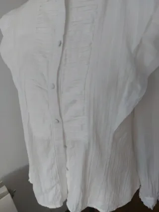 Camisa blanca con cuello alto y volantes