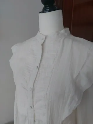Camisa blanca con cuello alto y volantes
