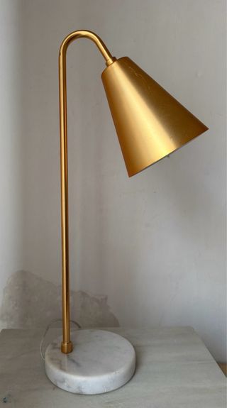 Lámpara de escritorio color dorado base mármol.