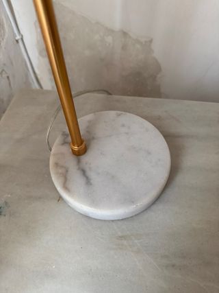 Lámpara de escritorio color dorado base mármol.