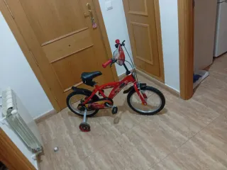 Bicicleta infantil roja con ruedas de apoyo