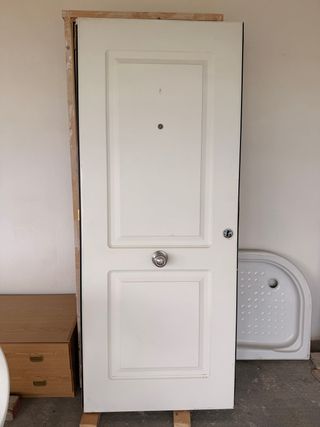 Puerta blanca con pomo y mirilla