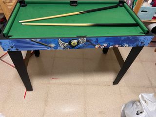 Mesa de billar con tacos y sin bolas