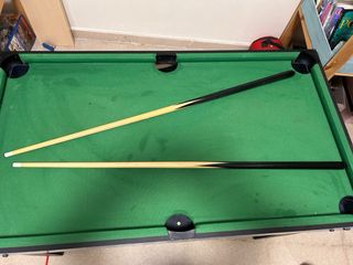 Mesa de billar con tacos y sin bolas