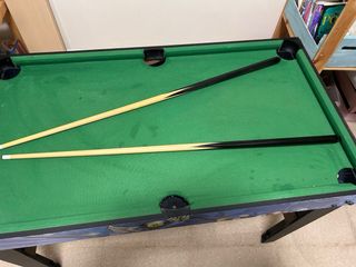 Mesa de billar con tacos y sin bolas