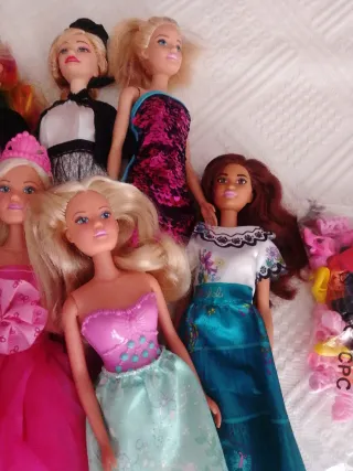 Lote de muñecas variadas, ropa y zapatos.