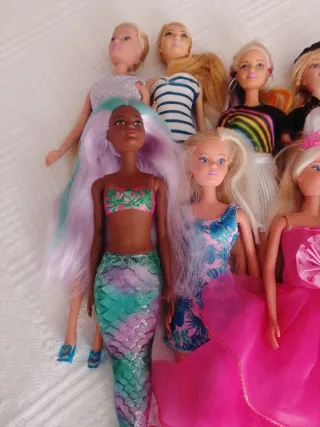 Lote de muñecas variadas, ropa y zapatos.