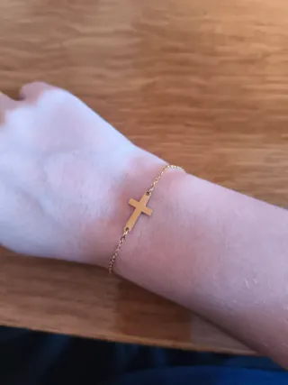 Pulsera dorada con colgante de cruz