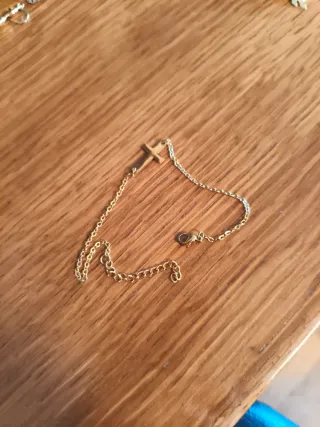 Pulsera dorada con colgante de cruz