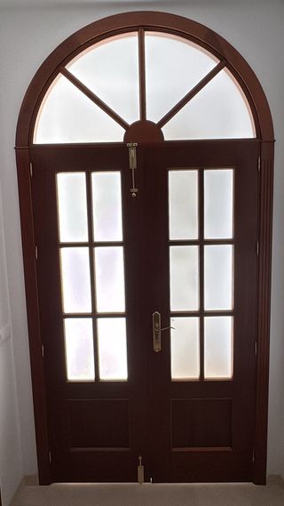Puerta con dos hojas de madera con cristal