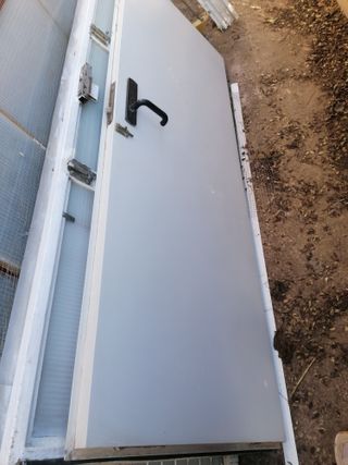 Puerta metálica blanca con su cuadro