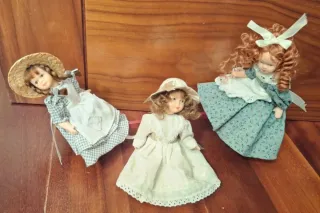 3 piccole bambole in porcellana e uno scivolo