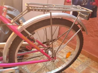 Bicicleta rosa con cesta y portaequipajes