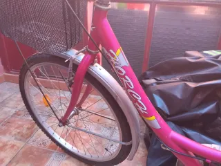 Bicicleta rosa con cesta y portaequipajes