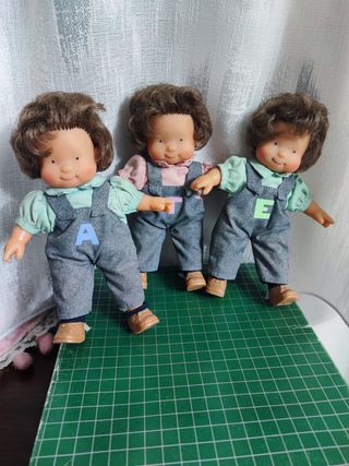 Tre bambole gemelle con salopette