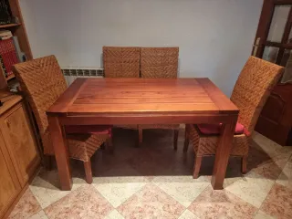 Mesa comedor madera y sillas de mimbre.