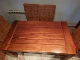 Mesa comedor madera y sillas de mimbre.