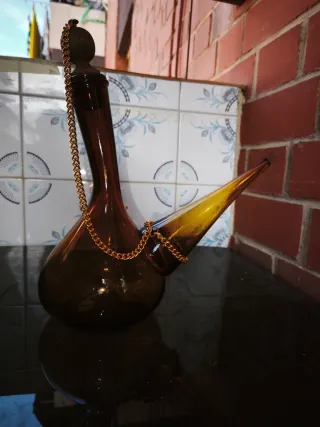 Porrón de vidrio con cadena dorada. Coleccionista