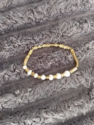 Pulsera elástica dorada con perlas