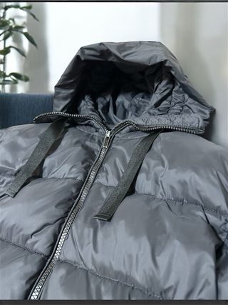 Abrigo negro acolchado con capucha.