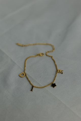 Pulsera Dior dorada con letras y estrellas