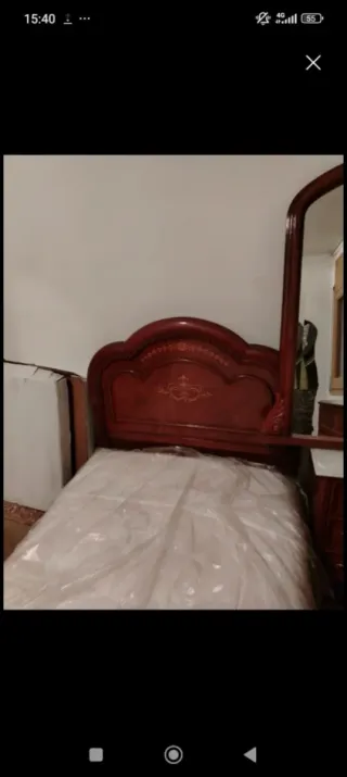Cama de madera con cabecero tallado