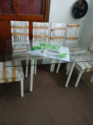 Mesa de cristal con 6 sillas blancas