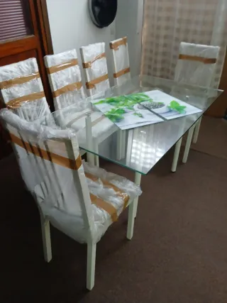 Mesa de cristal con 6 sillas blancas