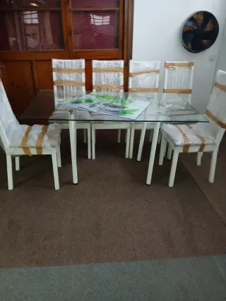 Mesa de cristal con 6 sillas blancas