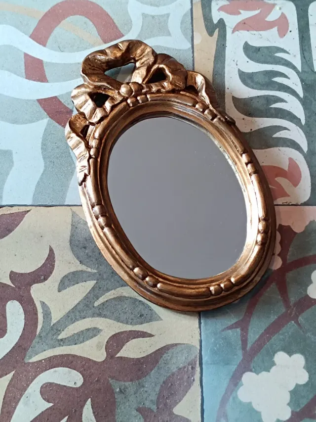 Espejo decorativo dorado con marco ornamentado