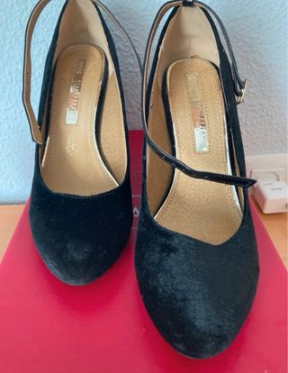 Zapatos de tacón negros de terciopelo con rosas.