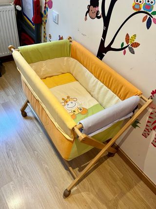 Mini cuna de madera con textiles coloridos