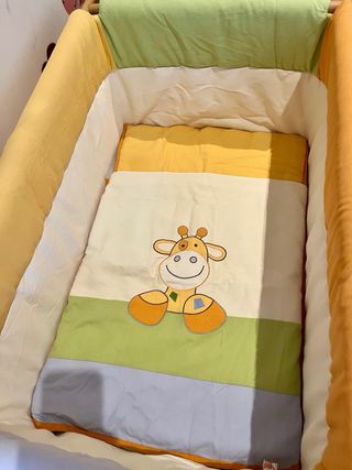 Mini cuna de madera con textiles coloridos