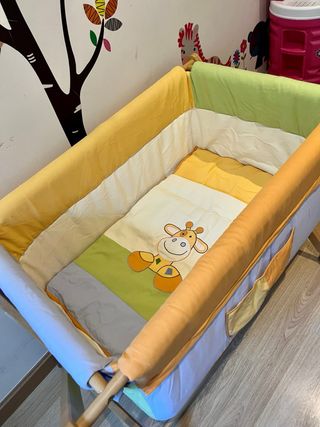 Mini cuna de madera con textiles coloridos