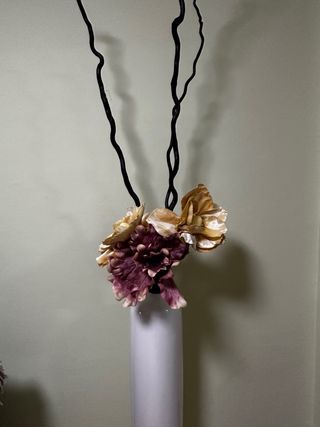 Jarrón blanco con flores y ramas