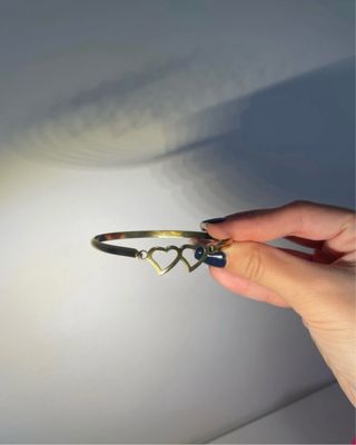 Pulsera dorada con dos corazones