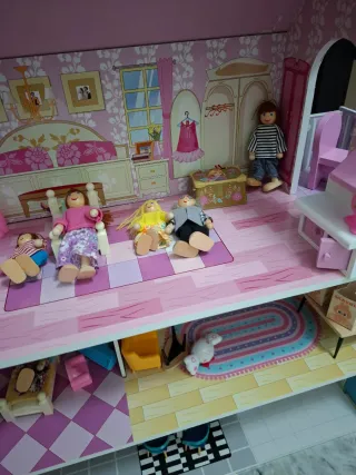 Casa de muñecas rosa con muebles