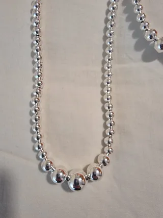 Collar y pulsera de bisutería plateada