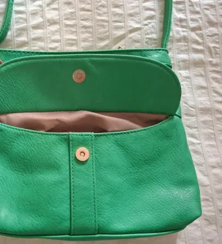 Bolso verde con cremalleras.
