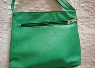 Bolso verde con cremalleras.