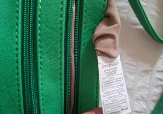 Bolso verde con cremalleras.