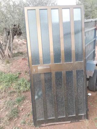 Puerta de aluminio color bronce con cristal