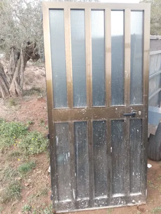 Puerta de aluminio color bronce con cristal