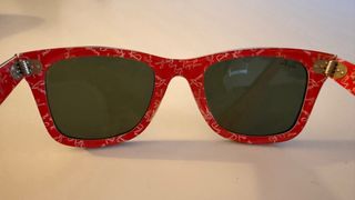 Gafas de sol Ray-Ban negras y rojas.