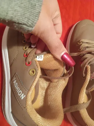 Zapatillas deportivas marrones con suela blanca.