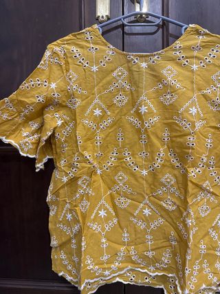 Camiseta mostaza con bordados blancos
